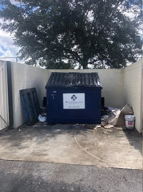 Before commercial cleaning in Proctor, MN — dirty commercial dumpster pad and grease buildup | Up North Pressure Washing
